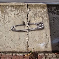 a piece of concrete that has been placed on the ground with a metal hook attached to it