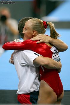 two female athletes hugging each other on the track