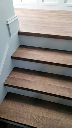 some brown stairs in a house with white walls