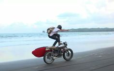 a man riding on the back of a motorcycle down a beach