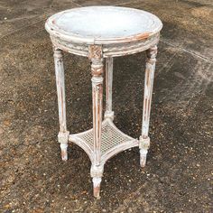 an old white table sitting on the ground