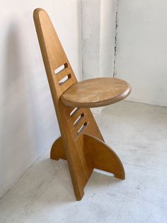 a wooden chair sitting on top of a white floor next to a wall and door