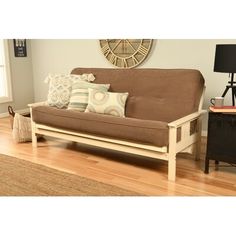 a living room with a futon couch and wooden floors in front of a clock