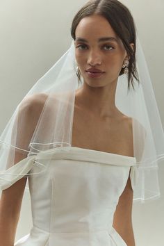 a woman wearing a white wedding dress and veil