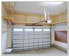 an empty garage with a basketball hoop hanging from the ceiling and overhead lighting above it