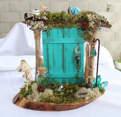 a small blue door with moss growing on it's sides and an animal figurine next to it