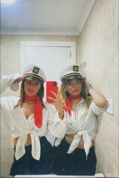 two women in sailor hats are taking a selfie