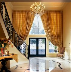 an elegant foyer with chandelier and marble flooring