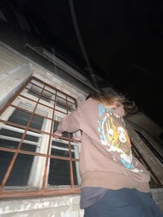 a person standing in front of an open window with bars on the outside and inside