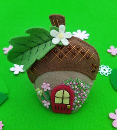 a small house made out of felt with flowers and leaves