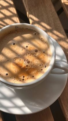 a cup of coffee sitting on top of a white saucer