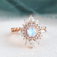 an engagement ring with a rainbow colored stone surrounded by white and rose cut diamonds on top