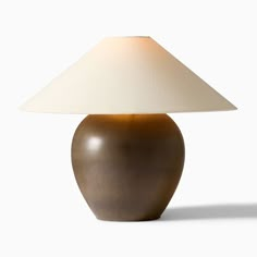 a brown table lamp with a white shade on it's base and a beige lampshade