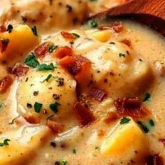 a wooden spoon filled with soup on top of a table