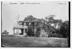 an old black and white photo of a large house in the middle of a field