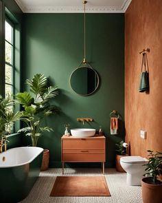 a bathroom with green walls and white fixtures, including a tub, toilet, sink and mirror