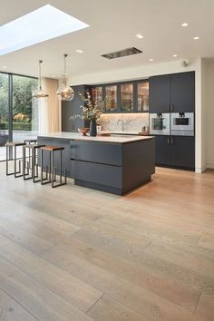 an open kitchen with wooden floors and skylights