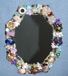 there is a mirror made out of beads and other things on the wall in front of it