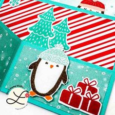 an open christmas card with a penguin on it and presents in front of the card