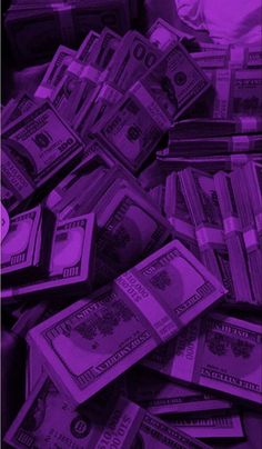 a pile of money sitting on top of a purple floor next to a white bag