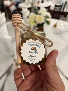 someone holding up a tiny jar of honey