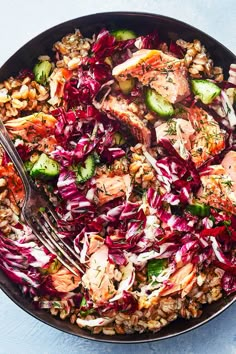 a bowl filled with meat, rice and veggies on top of a table