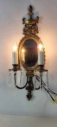 a wall mounted mirror with two candles on it