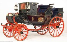 an old fashioned horse drawn carriage with red spokes and black leather interior, on white background