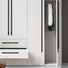 an open white closet with clothes hanging on the door and two wooden stools next to it