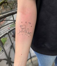 a person with a small tattoo on their arm that has an image of a dog and stars