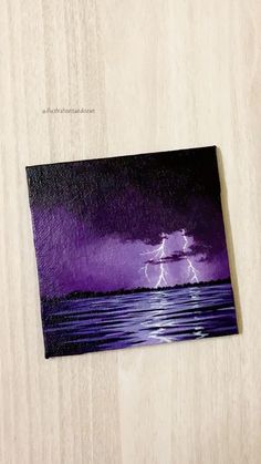 a painting of a lightning over the ocean on a wooden surface with text that reads diy acrylic paint