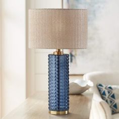 a blue table lamp sitting on top of a wooden table