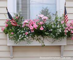 an american flag and flowers in a window box