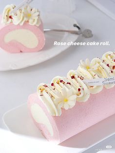 there is a pink cake with white frosting and flowers on the top, next to another piece of cake