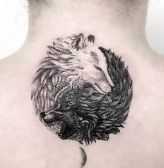 the back of a woman's neck with a wolf and moon tattoo on it