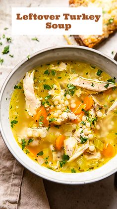 a white bowl filled with chicken and barley soup next to a slice of bread on a napkin