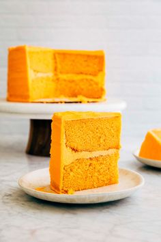 two plates with slices of orange cake on top of each other and one slice missing