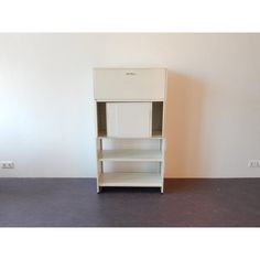 an empty white shelf in the corner of a room