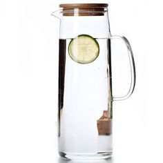 a glass pitcher with a slice of cucumber in the bottom and brown lid