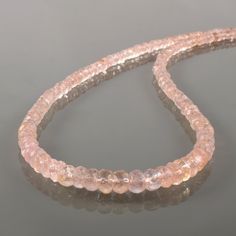 two pink beads sitting on top of a reflective surface