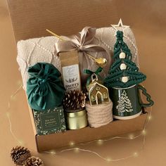 Embrace the spirit of the season with this Deluxe Holiday Gift Basket, the ultimate hygge-inspired set designed for warmth, comfort, and festive joy. Ideal for sharing holiday cheer with loved ones, clients, or colleagues. ▬▬▬▬▬▬▬▬▬▬▬▬▬▬▬▬▬WHAT'S INSIDE:▬▬▬▬▬▬▬▬▬▬▬▬▬▬▬▬▬ ✭ Acrylic throw blanket (50x60") ✭ Sea salt caramel cocoa cookies (2 oz) ✭ Salted caramels in a Santa bag ✭ Scented candle (vanilla cookie) ✭ Ground coffee (2 oz) ✭ Soft socks (fits sizes 6-12) ✭ Gold spoon ✭ Gold plated ceramic Cozy Home Gift Basket, Throw Blanket Gift Ideas, Blanket Gift Basket Ideas Christmas, Christmas Gift Bundle Ideas, Christmas Blanket Gift Ideas, Warm And Cozy Gift Ideas, Thanksgiving Box Care Packages, Coffee Mug Christmas Gift Ideas Filled, Christmas Mug Gift Ideas Filled