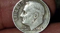 a close up of a person's finger with a coin in the foreground