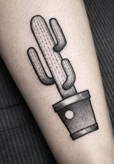 a cactus in a pot tattoo on the left inner forearm and leg, with dots around it