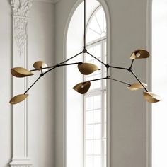 a modern chandelier hanging from the ceiling in a room with white walls and windows