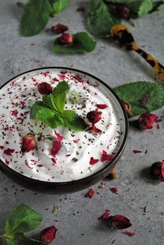 a small bowl filled with whipped cream surrounded by leaves