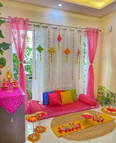 a living room decorated in bright colors with pink drapes and yellow pillows on the floor