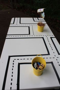 two buckets filled with candy sitting on top of a white tablecloth covered in black and white lines