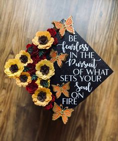 a graduation cap with flowers and butterflies on it that says be fearless in the pursuit of what sets your soul on fire