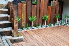 some plants are growing on the side of a wooden fence