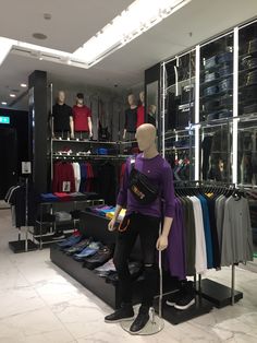 a mannequin in a clothing store with lots of clothes on display